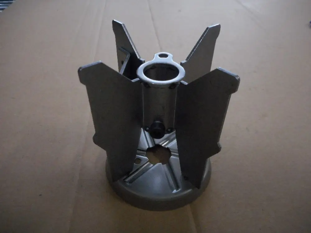 Remeha Turbulator, metallisches Teil mit fünf verstellbaren Lamellen, zentraler Öffnung und runder Basis, auf braunem Kartonhintergrund abgebildet.